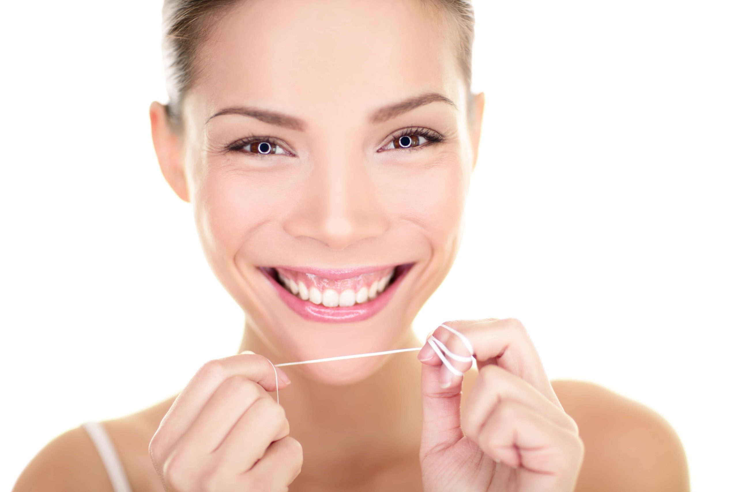 Woman Flossing Teeth While Smiling